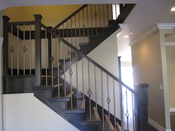 Interior stair with milled newel posts and iron balusters