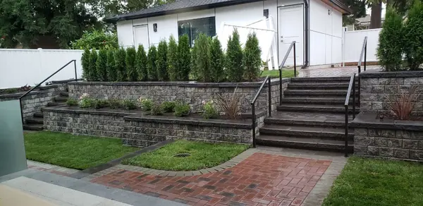 Rear garden with stone retaining wall and brick terrace
