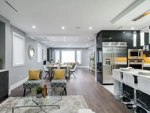 High-gloss dark kitchen with amber backsplash and illuminated wine display